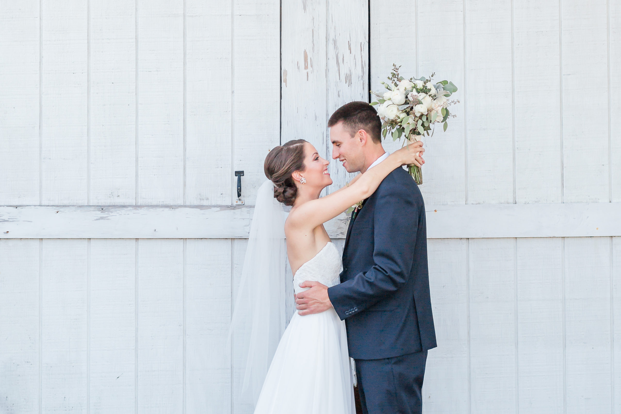 massachusetts wedding photographer bride and groom in front of barn wall